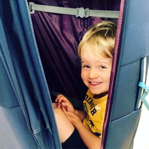 Toddler hiding in the suitcase before holiday