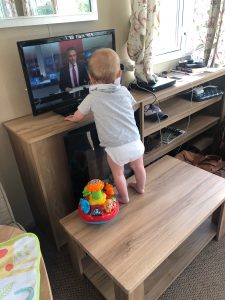 Toddler climbing on a coffee table in a caravan