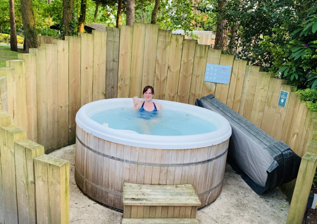 A woman in a hot tub at Sandy Balls one of the best places to stay near Paultons Park and Peppa Pig World