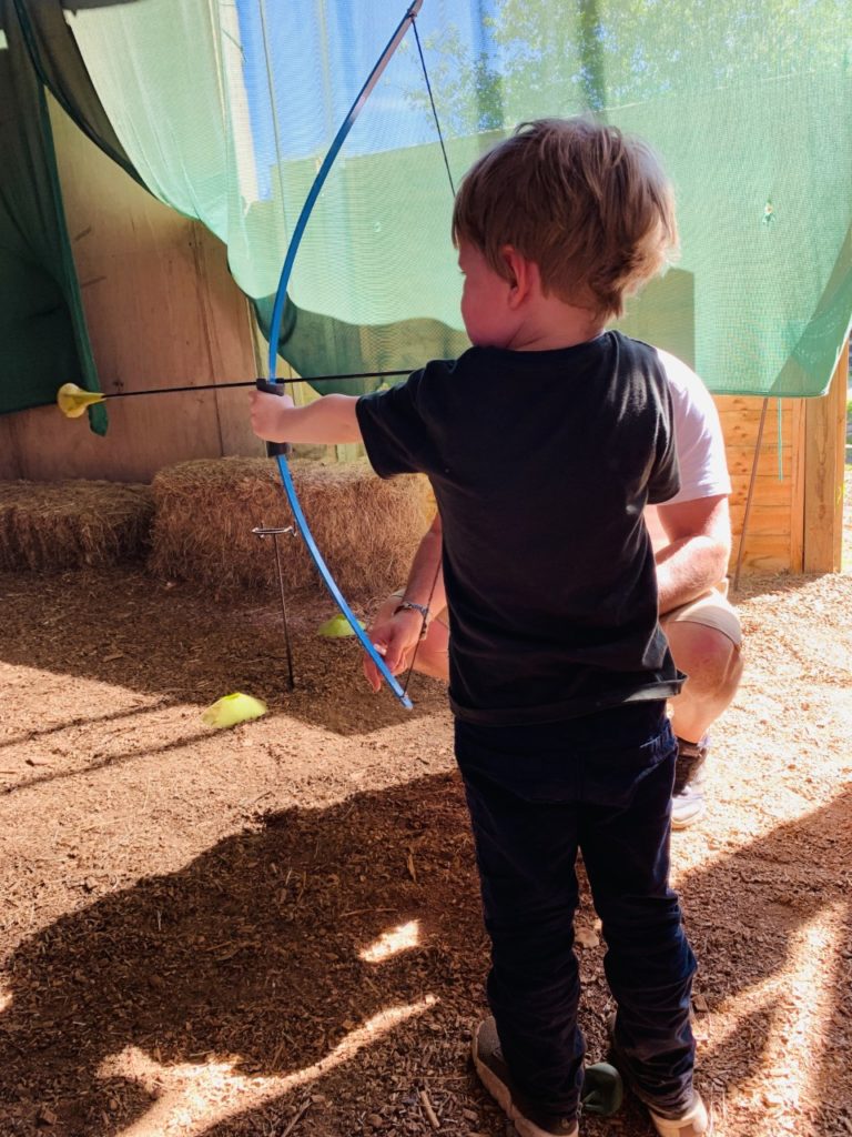 Thomas trying out mini archery at Sandy Balls