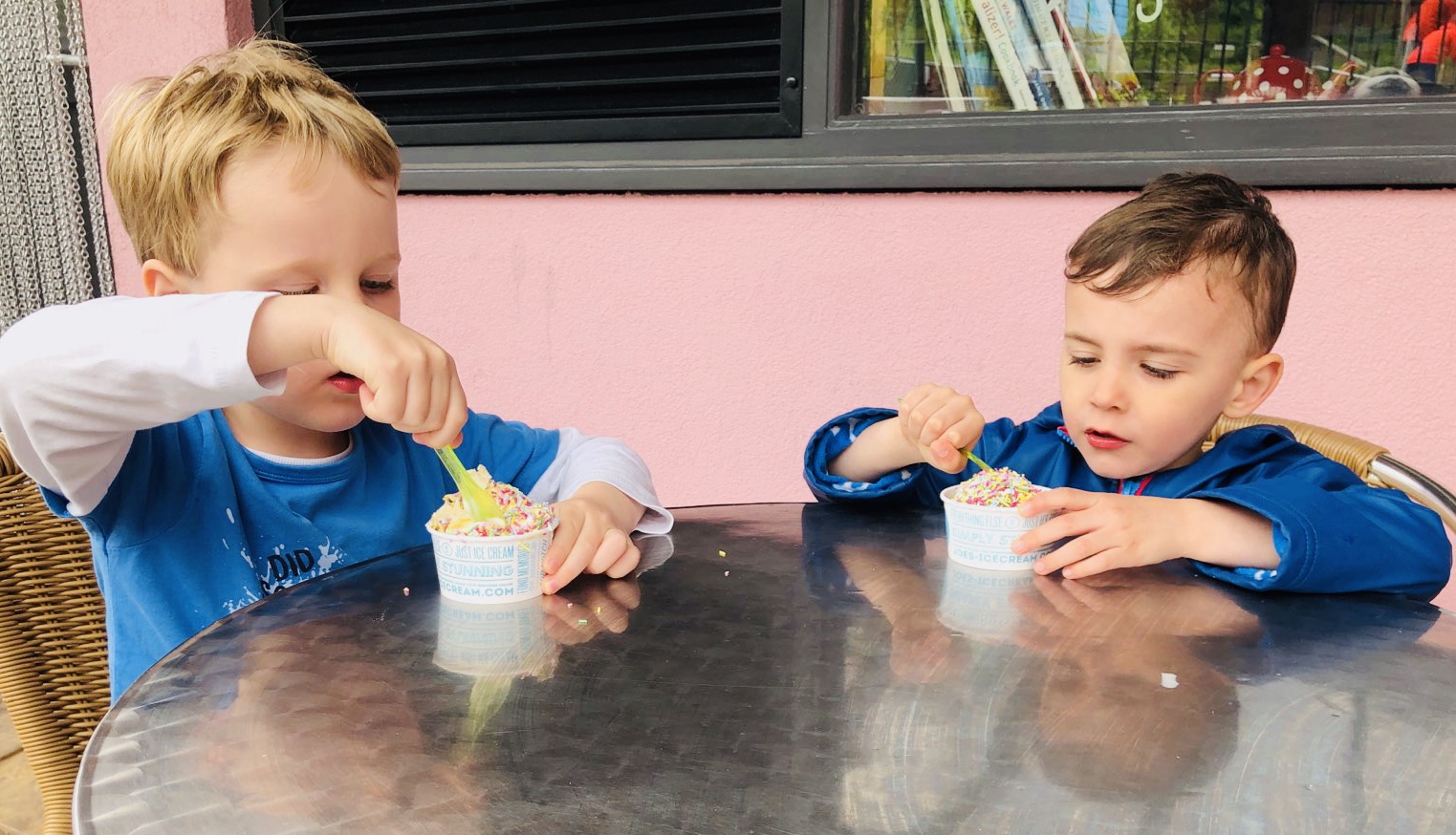 Four year olds eat ice cream together on holiday