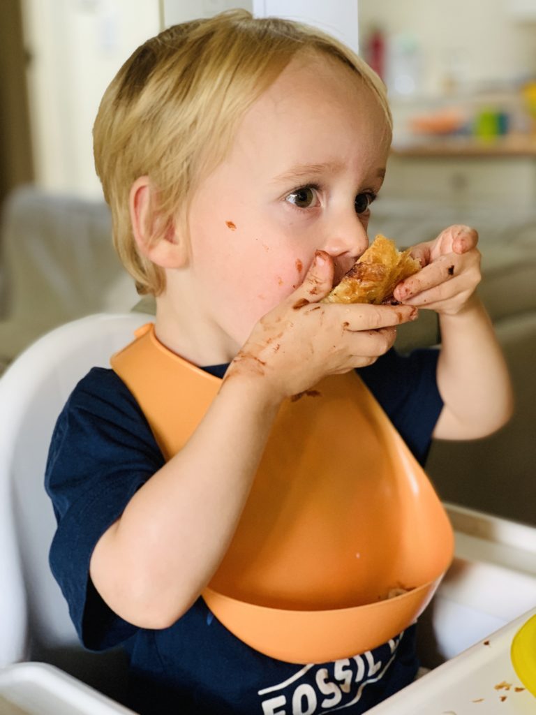 Toddler enjoying a pain au chocolat