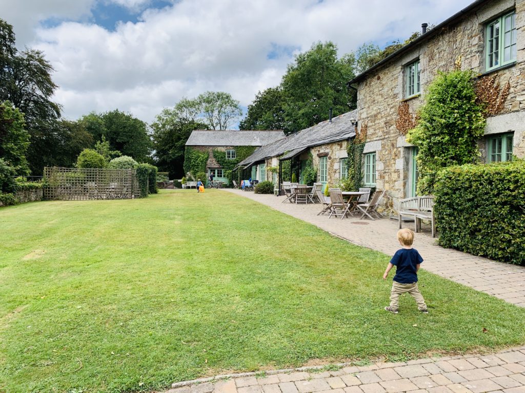 Toddler on the lawn of Glynn Barton cottages one of the best UK family holidays