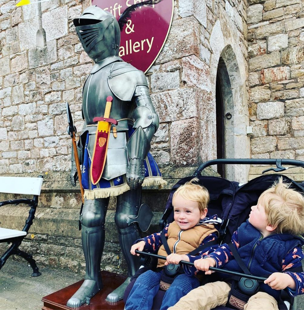 Twins looking at a knight's armour at Powderham Castle in Devon