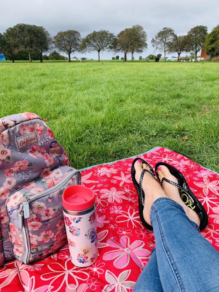 feet on a flower picnic rug at mums meet up