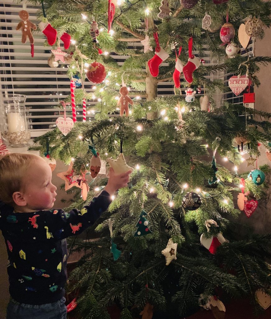 Toddler taking decorations off the Christmas tree