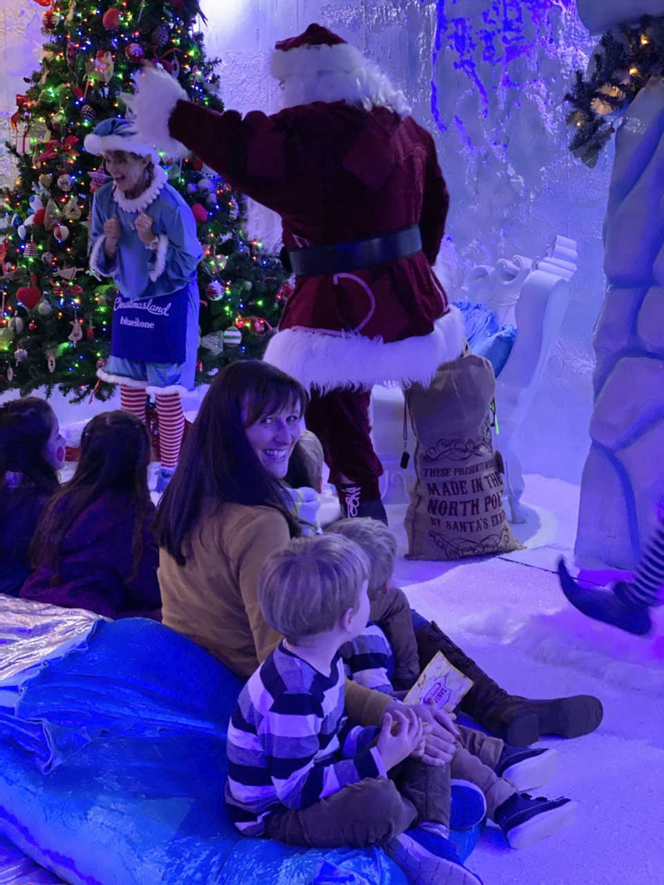 Family watch Santa arrive in his workshop at Bluestone's Christmasland