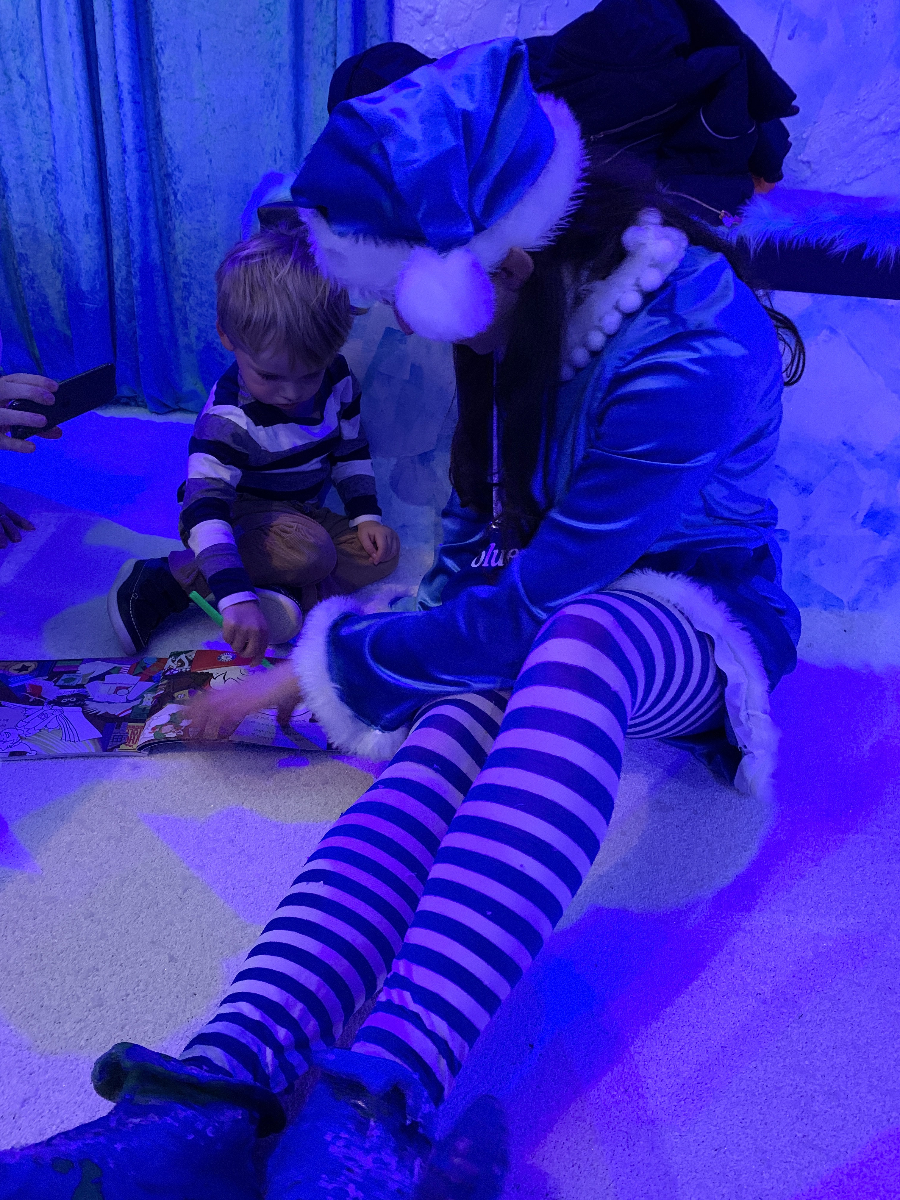 A Bluestone elf chats to a toddler at Christmasland