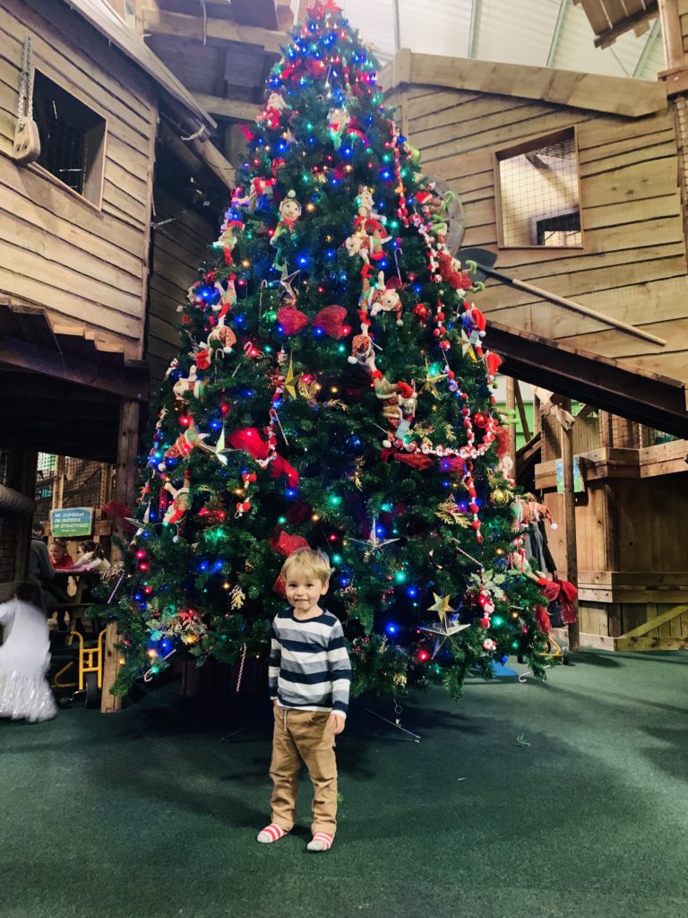 Toddler with a Christmas tree at Christmasland, Bluestone