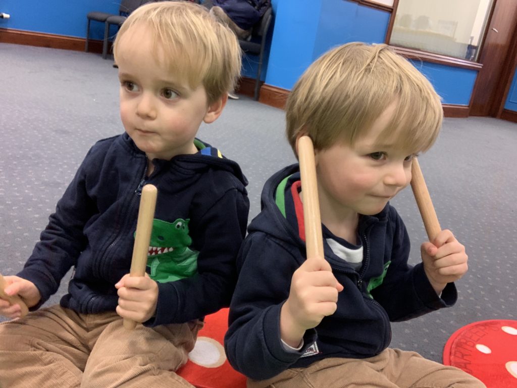 Toddlers using musical claves at a Hartbeeps group