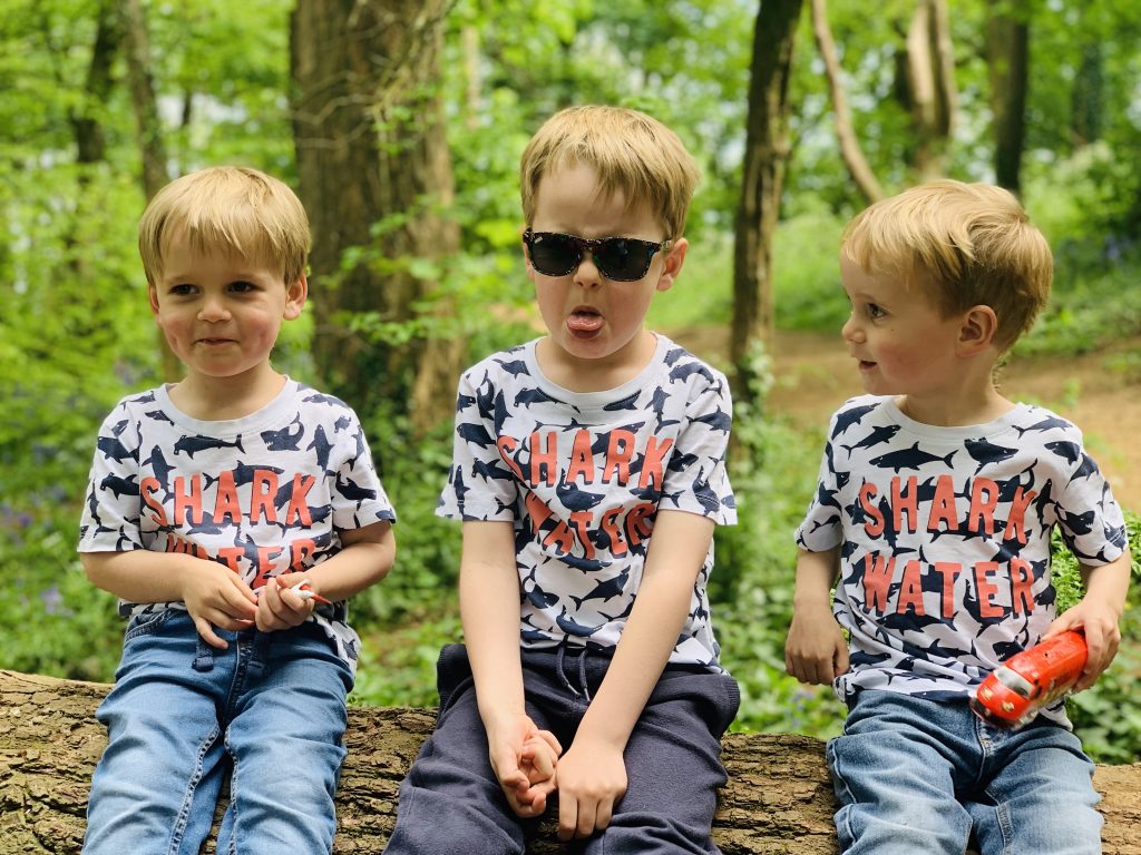 Four year old looking stroppy with his brothers in the woods