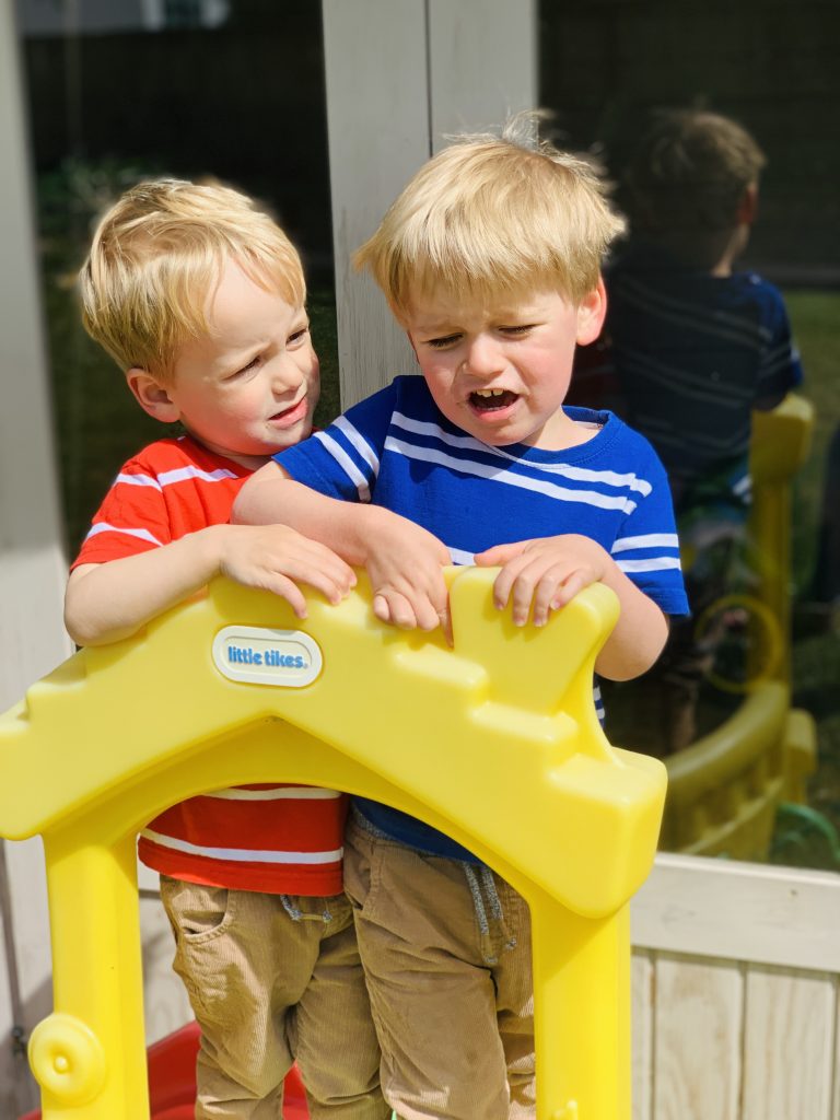 Twins fight over a slide