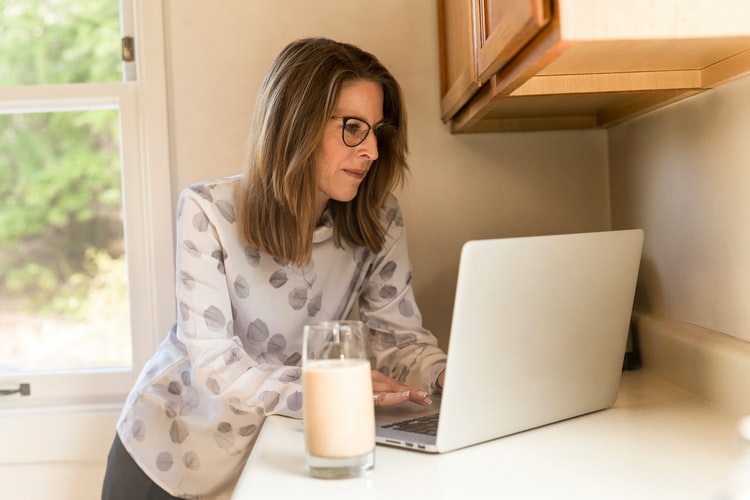 woman works on her business at home after having a baby