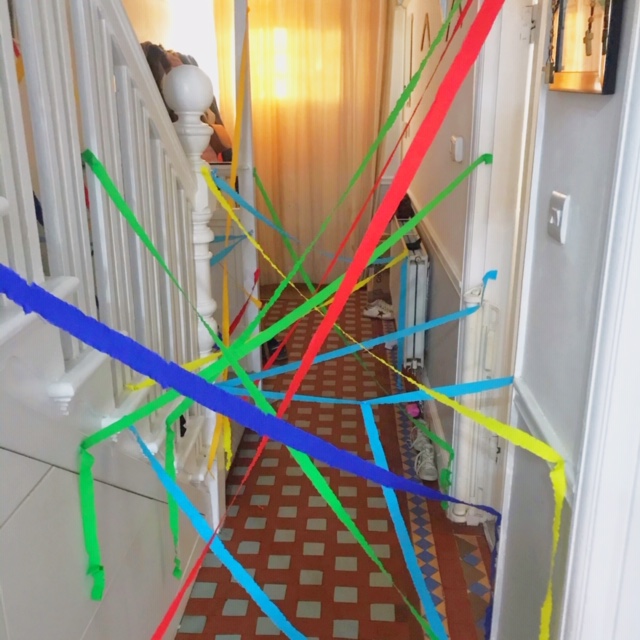 Crepe paper stuck across the hallway for a birthday party at home activity