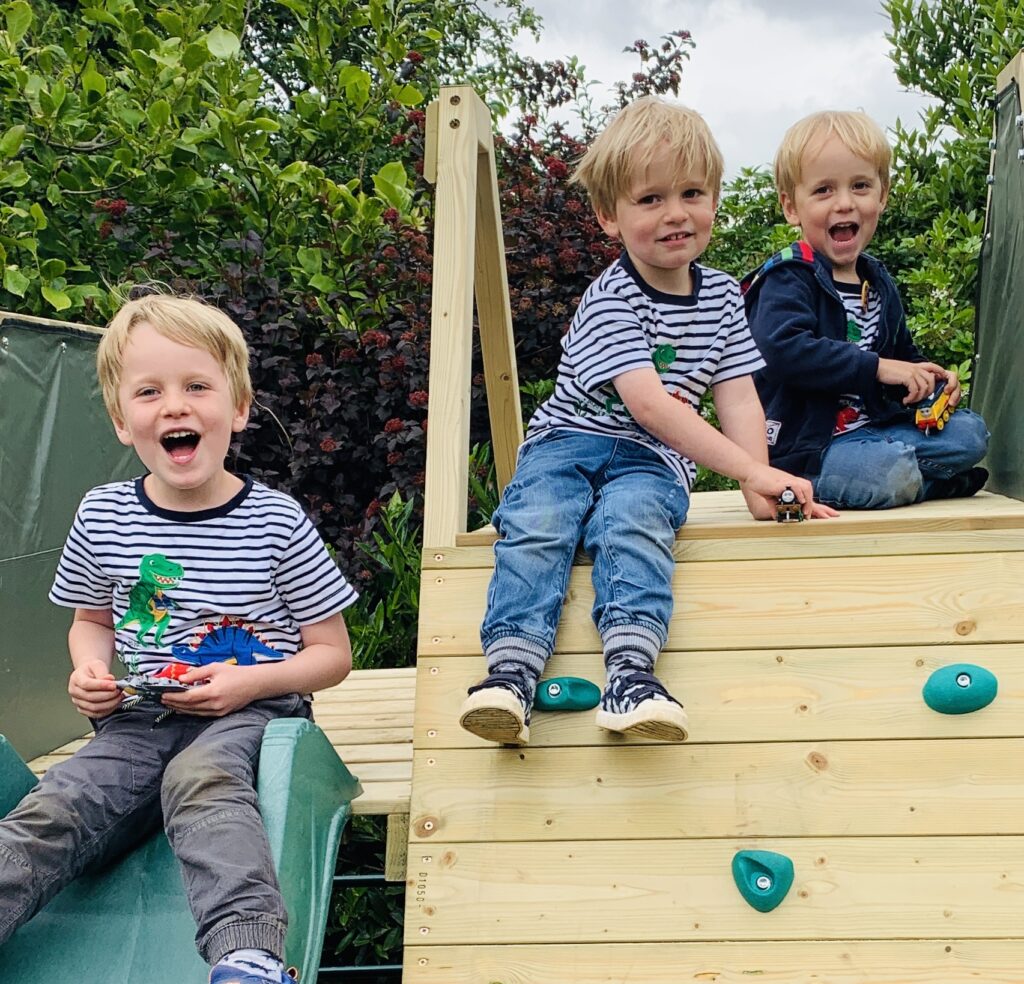 Brothers sitting on a climbing frame in their family-friendly garden in lockdown