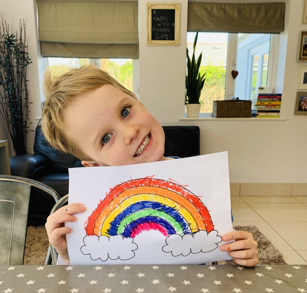 Little boy with the rainbow he's drawn