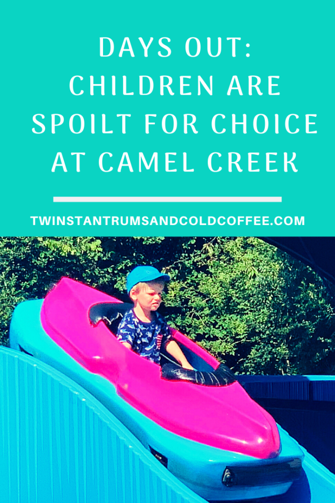 PIN image of a toddler in a mini log flume ride at Camel Creek Adventure Park in Cornwall