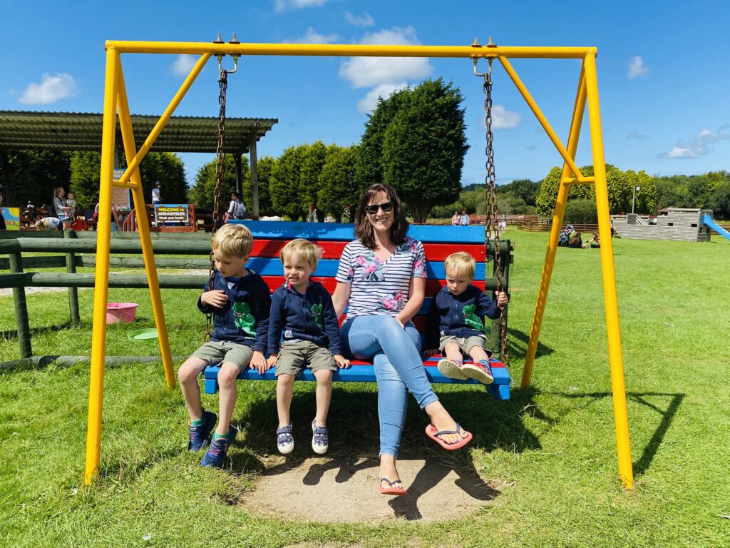 Mum and three boys on a swinging seat at Springfields fun park