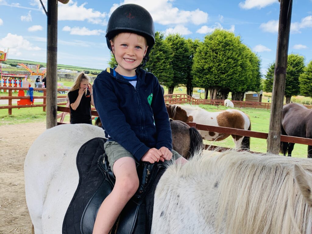 Five year old boy happy on a pony ride