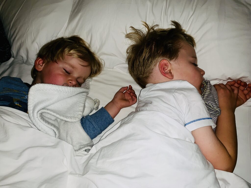 Brothers asleep in their mum and dad's bed