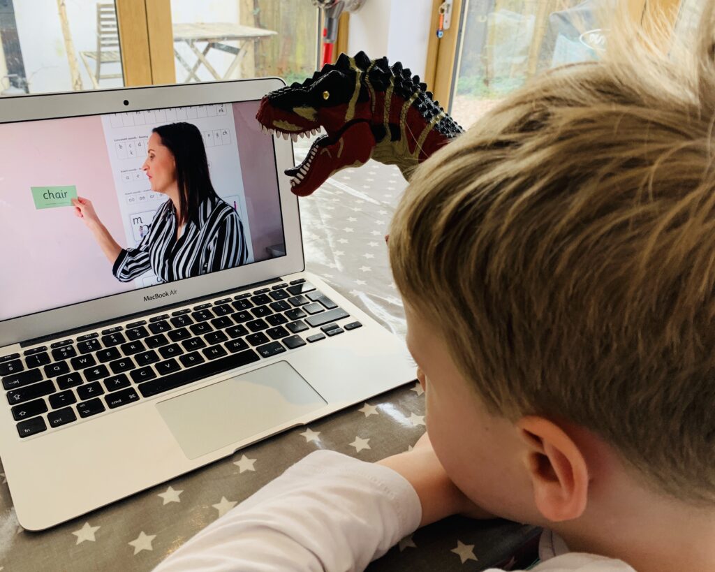 Five year old watches a phonics video before going back to school during Covid