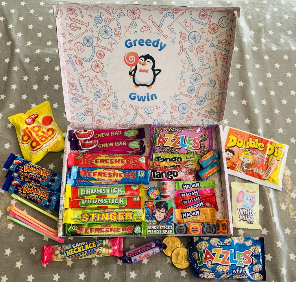 A cardboard hamper filled with lots of packets of retro sweets