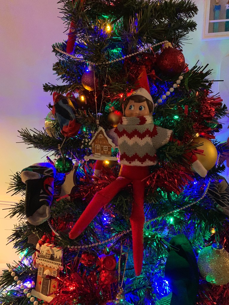 Elf toy hanging in a Christmas tree