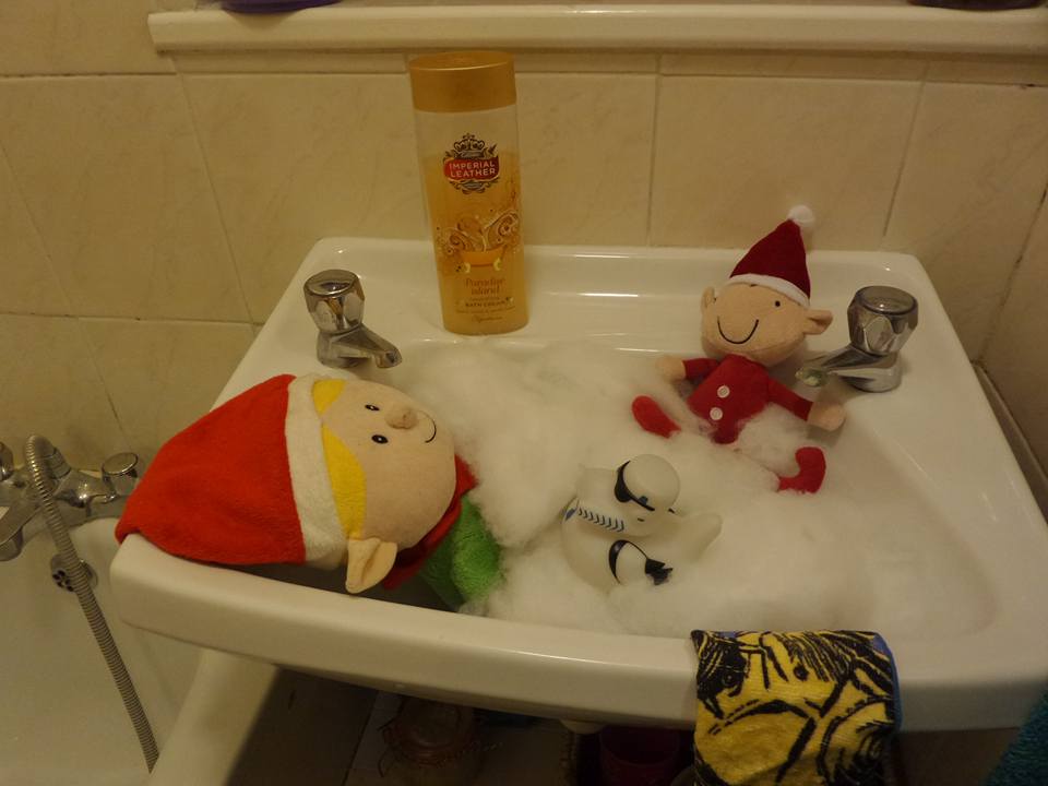 Elf toys take a bath in a sink