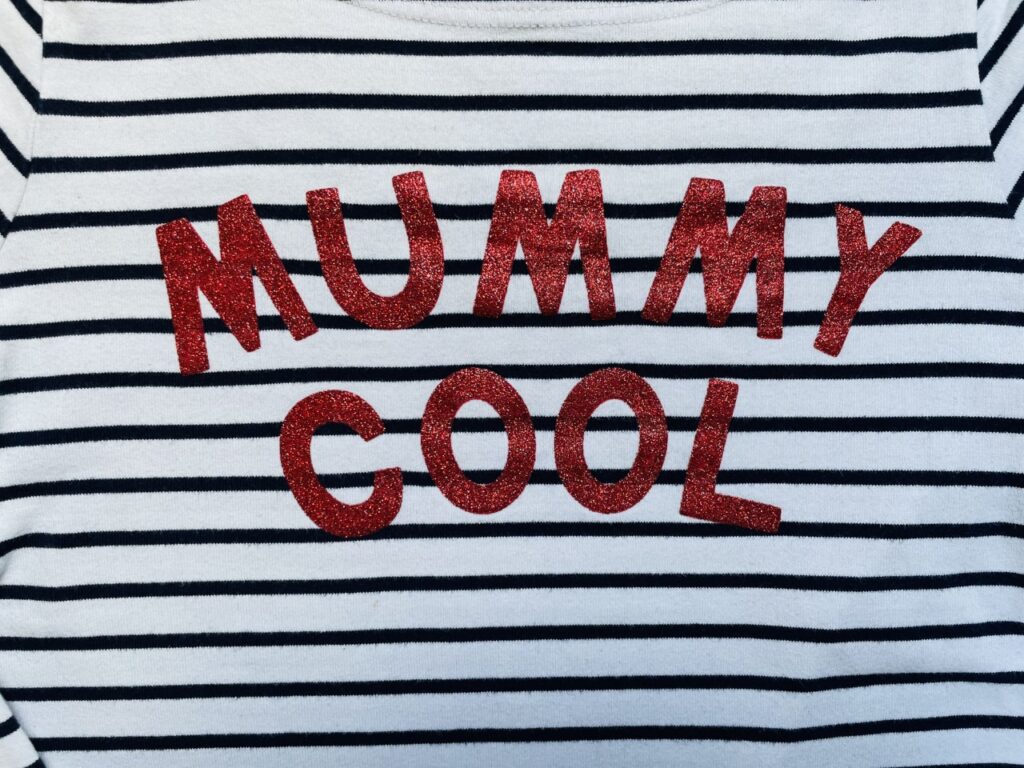 Red glittery 'Mummy Cool' slogan on a black and white stripey t-shirt