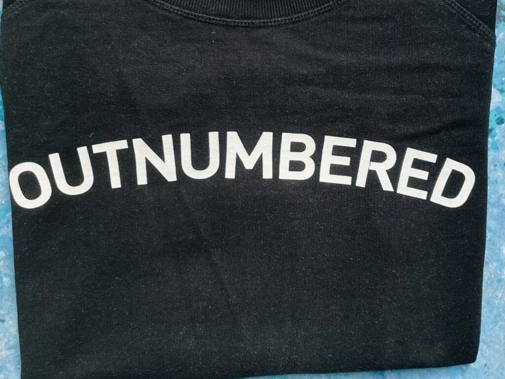 'Outnumbered' slogan in white writing on a black sweatshirt