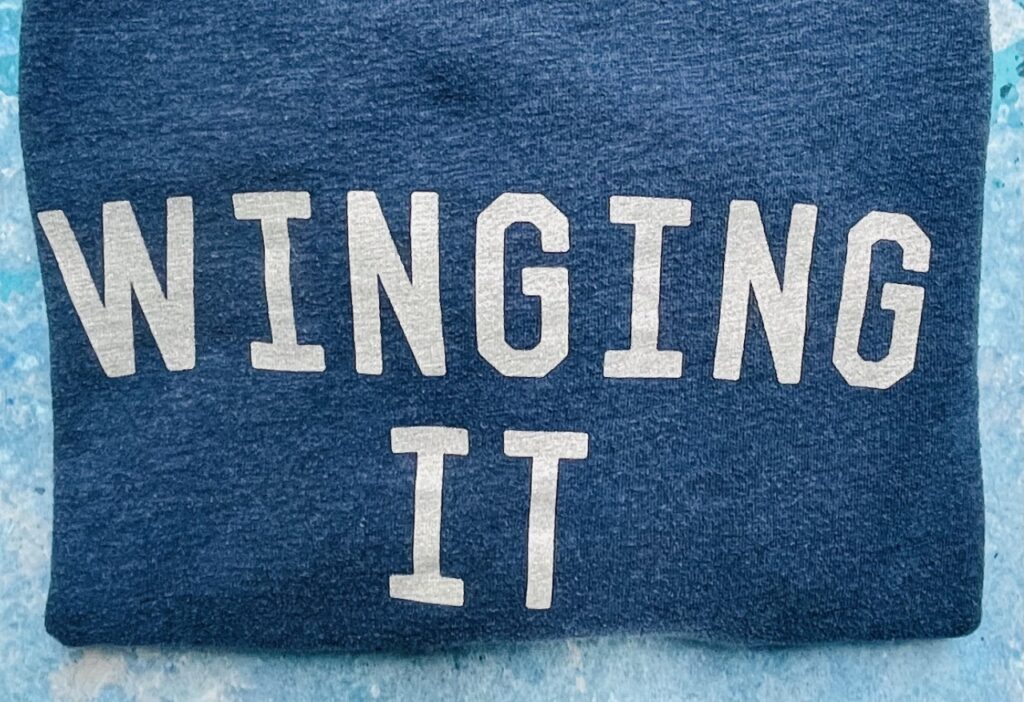 'Winging it' slogan on a navy blue sweatshirt