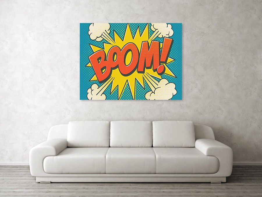 A white sofa next to a grey wall. Above the sofa is a green,yellow and red poster print of the word Boom 