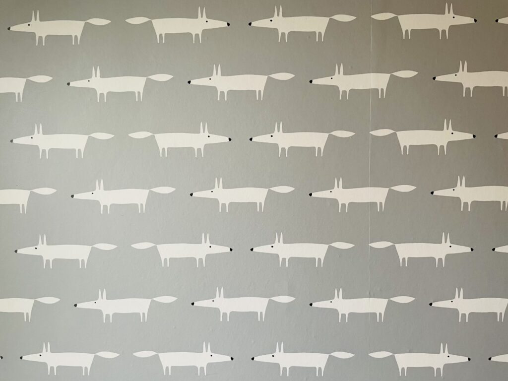 Grey wallpaper with white foxes on it