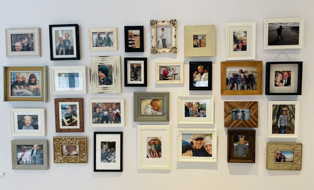 A piece of wall art consisting of a picture gallery of family photos on a kitchen wall 