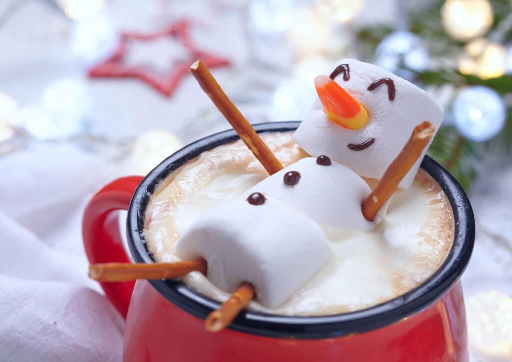 Marshmallows in the shape of a snowman resting on the top of a hot chocolate