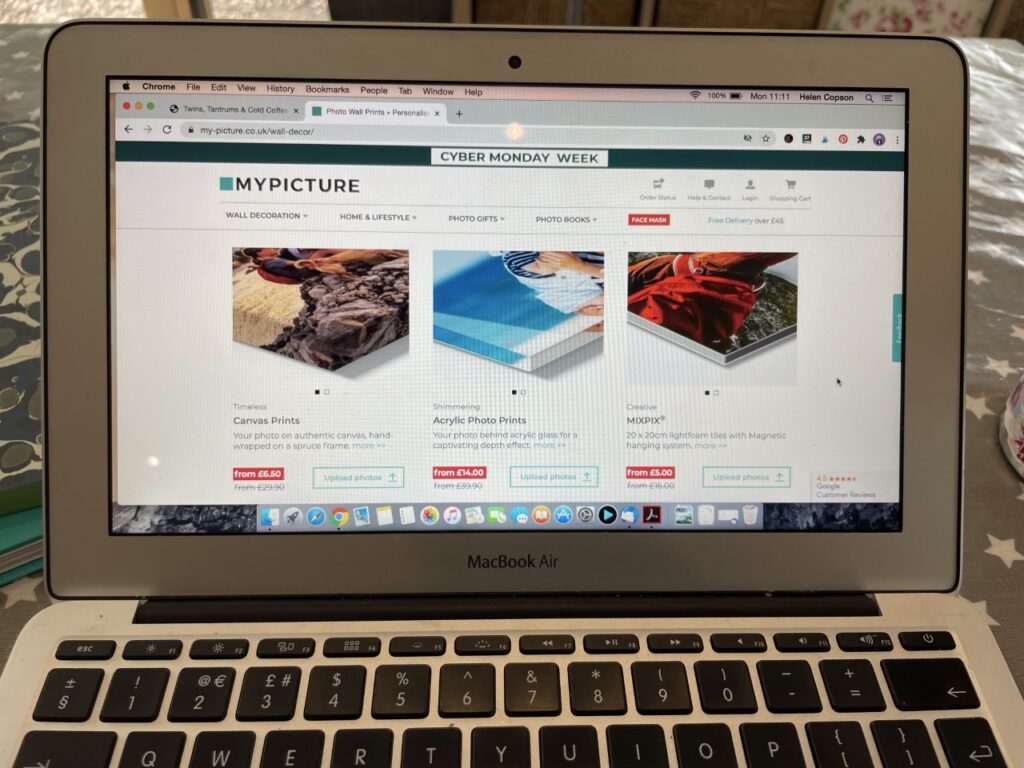 A laptop screen on a table showing a website where you can print out photos