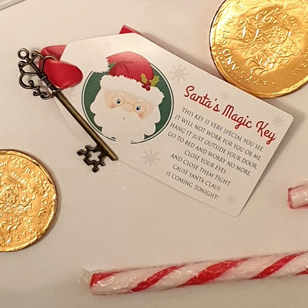 Santa key with label on it and chocolate coins and candy cane. An idea for Christmas Eve Boxes.