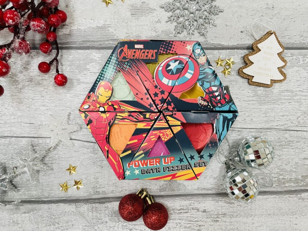 Avengers bath fizzers set surrounded by Christmas decorations on a grey background