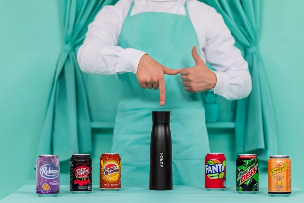 Auron drinks bottle next to cans of fizzy drinks