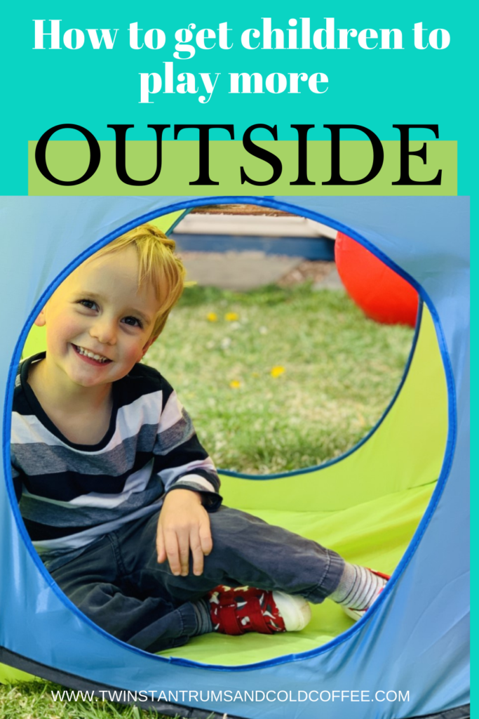 Little blonde boy inside a pop up tent in the garden as a way of getting children outside more