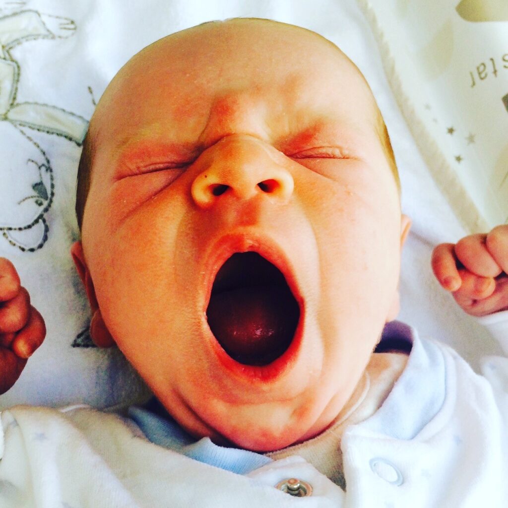 Baby yawning his head off for a post with tips on a sleep schedule 