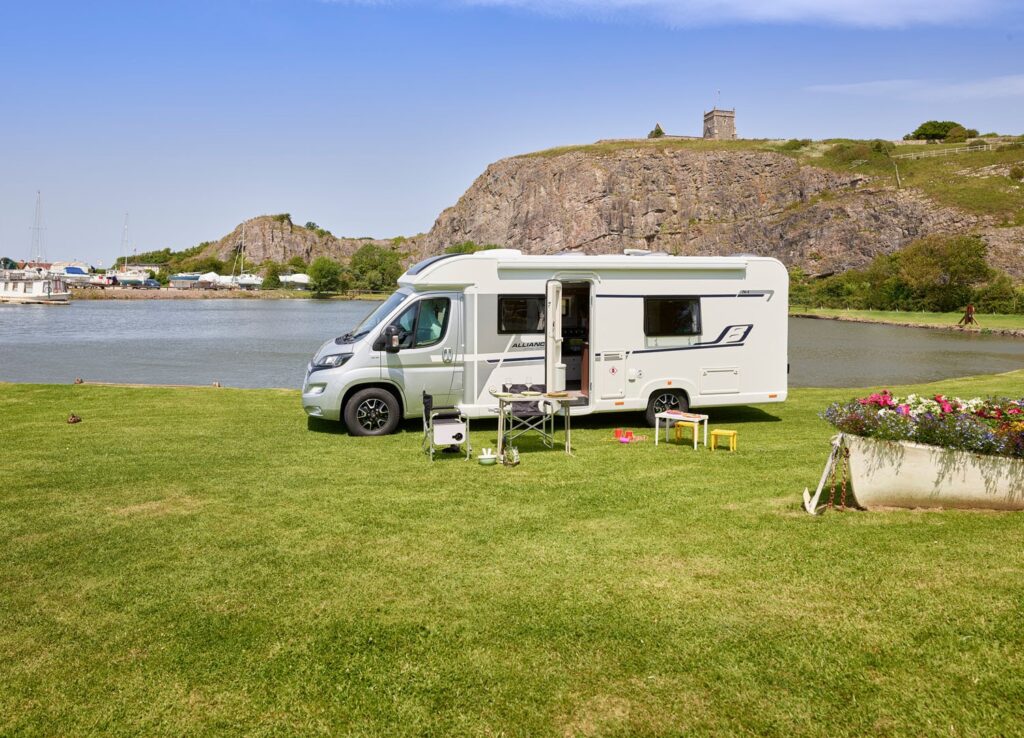 A Bailey motorhome parked next to a lake and castle