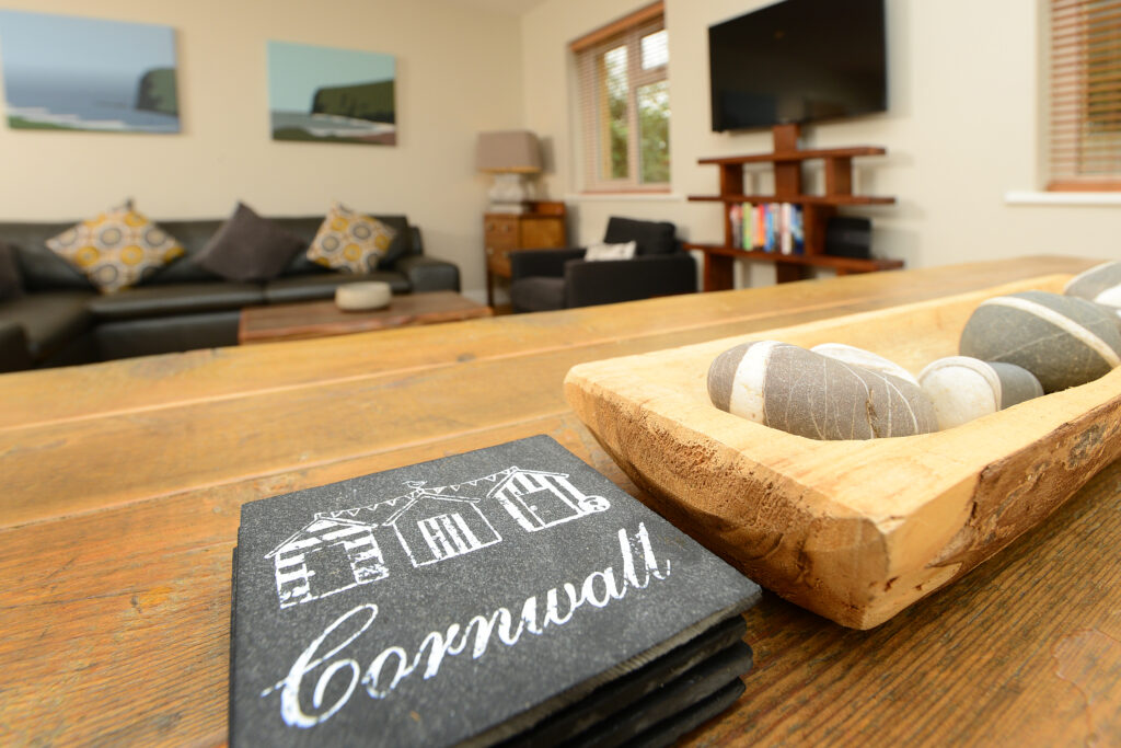 Slate coasters on a wooden table at Gwelmor holiday home in north cornwall