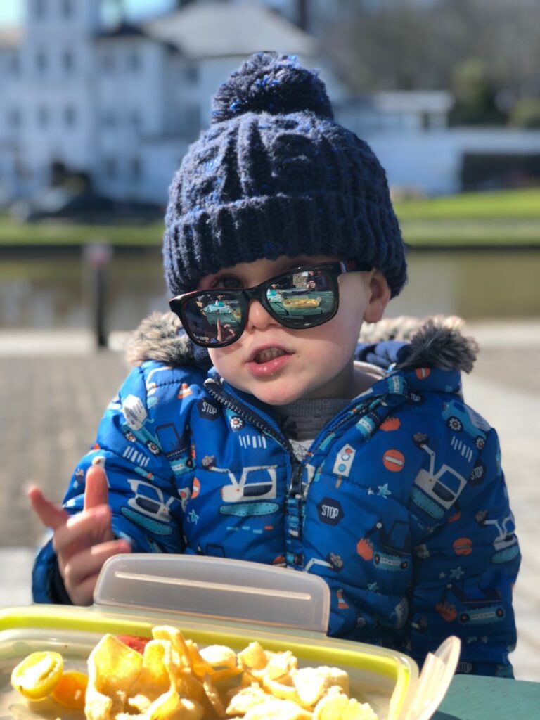 Toddler boy in woolly hat and sunglasses