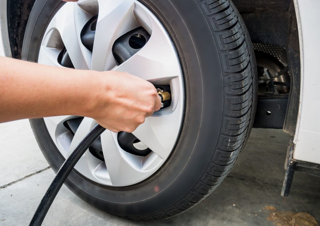 A tyre and hand checking pressure and adding air