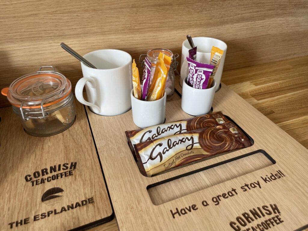 A wooden board containing sachets of squash and hot chocolate, and marshmallows at the Esplanade Hotel