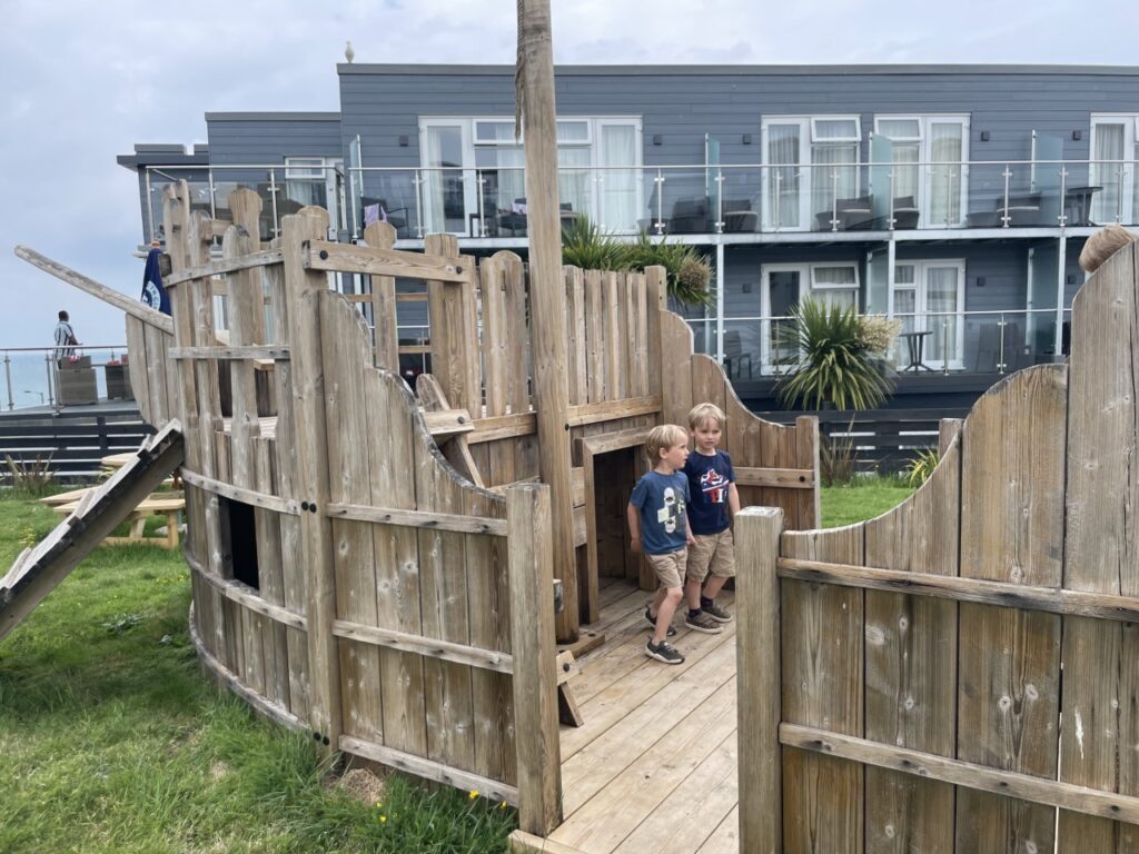 Twin four year old boys play in a pirate ship