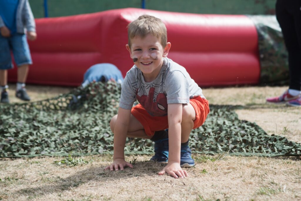 A boy wearing war pain on his face plays on an inflatable 