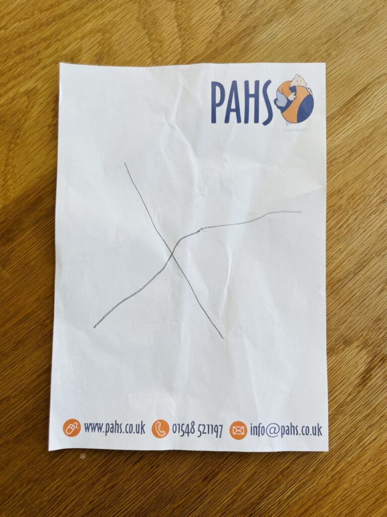 A piece of paper with a cross on it drawn in pencil