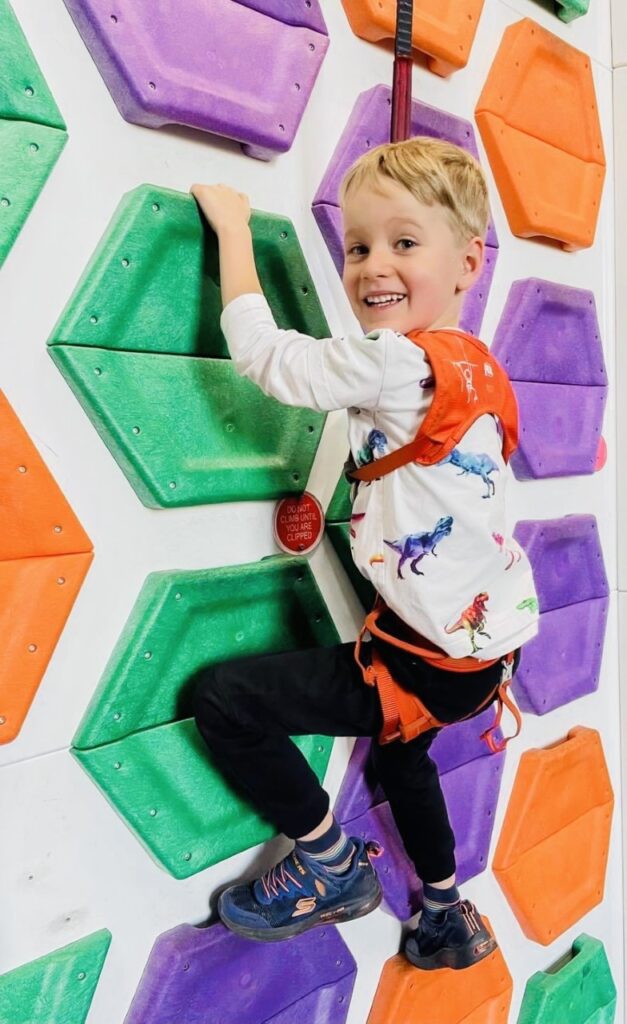 Five year old boy on a climbing wall at Clip n Climb in Plymouth